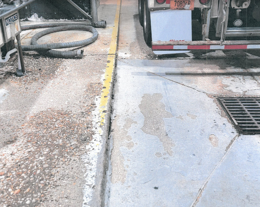 Pitting and worn concrete damaged by water and chemicals in a Delaware tank wash facility.
